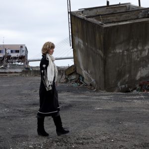 Adi Roche of Chernobyl Children International walking by destroyed buildings seaside in Soma City, Fukushima Prefecture