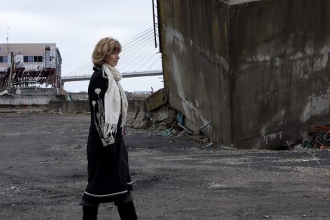 Adi Roche of Chernobyl Children International walking by destroyed buildings seaside in Soma City, Fukushima Prefecture